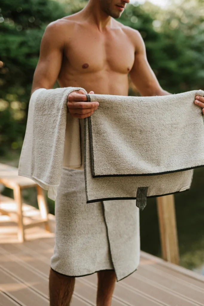 mężczyzna trzymający lniany ręcznik do sauny frotte natural black