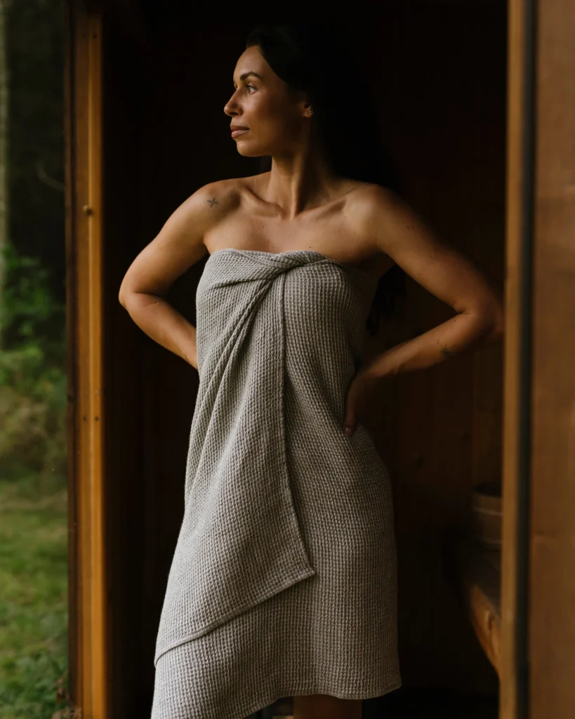 Kobieta przed sauną w ręczniku do sauny len wafel natural grey.