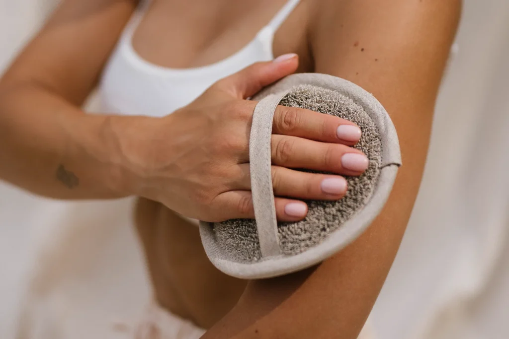 kobieta peelingująca skórę krążkiem podczas przerwy w sensie saunowania